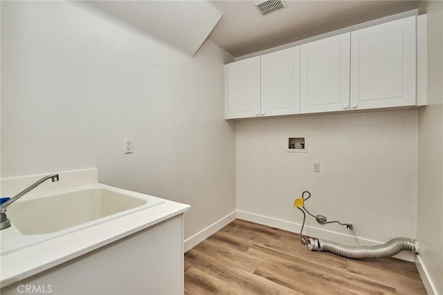 laundry area featuring cabinets, hookup for a washing machine, light hardwood / wood-style floors, and sink