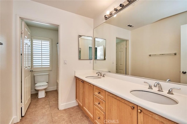 bathroom featuring tile patterned floors, vanity, and toilet