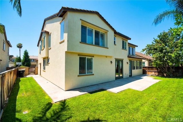 back of property with a patio area and a yard