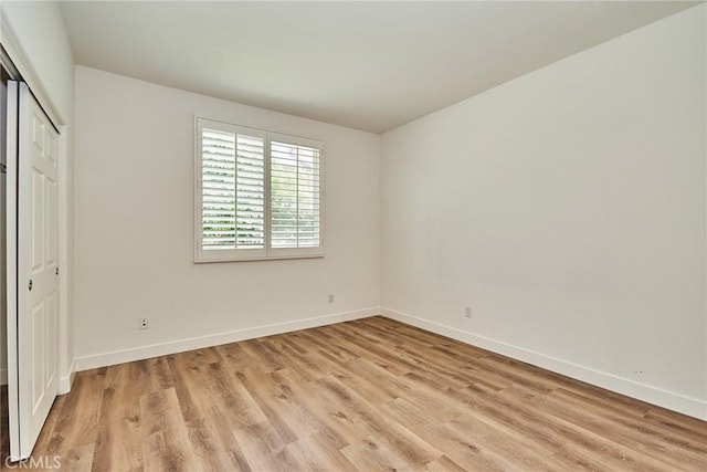 unfurnished bedroom with light hardwood / wood-style floors and a closet