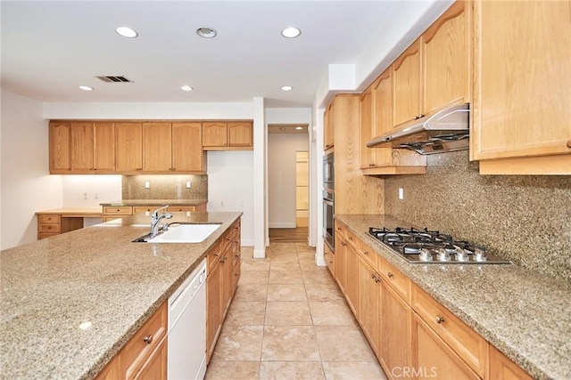 kitchen with appliances with stainless steel finishes, tasteful backsplash, light stone counters, sink, and light tile patterned flooring