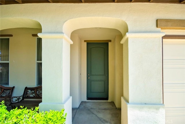 entrance to property with covered porch and a garage