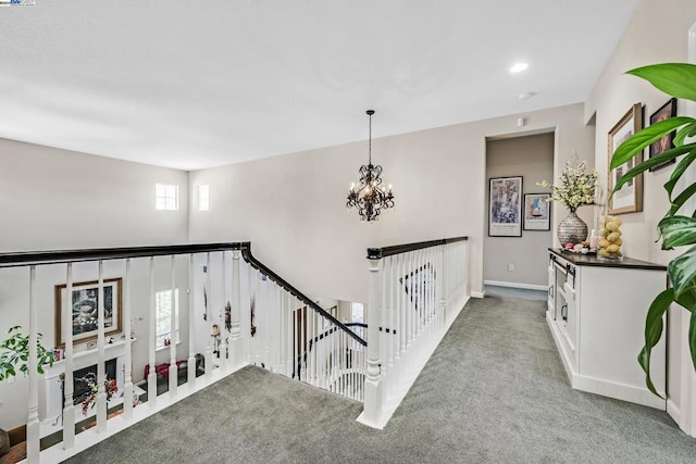 staircase with a notable chandelier, carpet flooring, and a healthy amount of sunlight