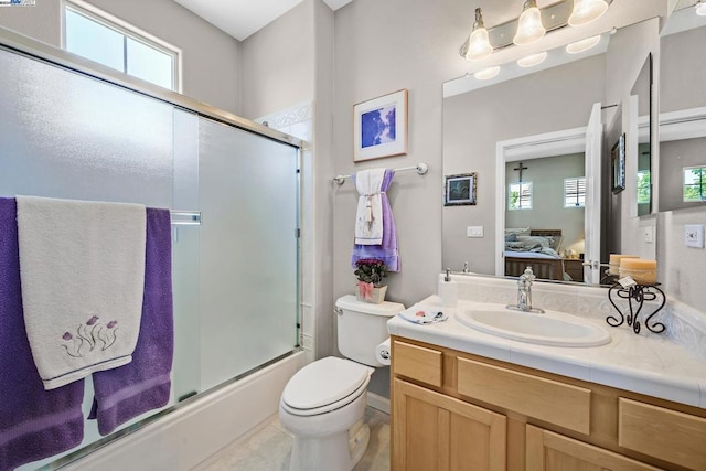 full bathroom featuring tile patterned floors, shower / bath combination with glass door, vanity, and toilet