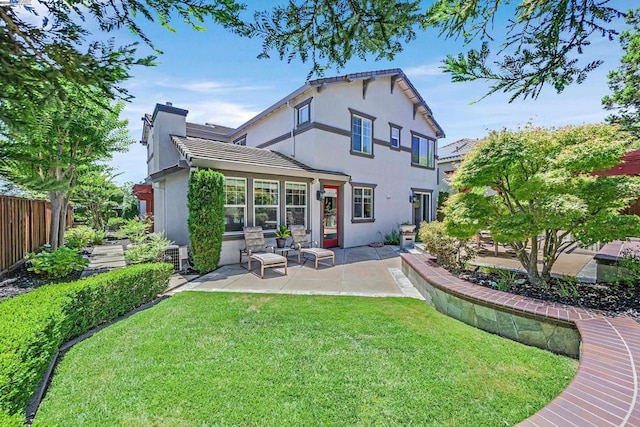 back of property with a lawn and a patio area