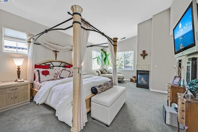 bedroom featuring lofted ceiling, carpet, and multiple windows