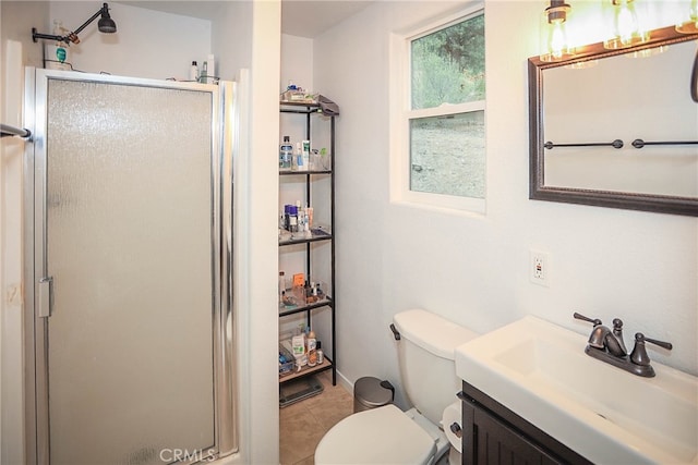 bathroom with tile patterned flooring, an enclosed shower, vanity, and toilet