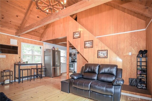 living room featuring light wood-type flooring, beamed ceiling, wood walls, and wooden ceiling