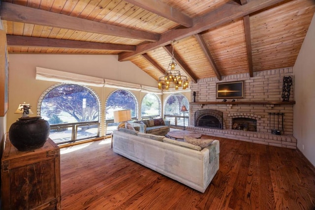 living room with hardwood / wood-style flooring, lofted ceiling with beams, a notable chandelier, a brick fireplace, and wooden ceiling