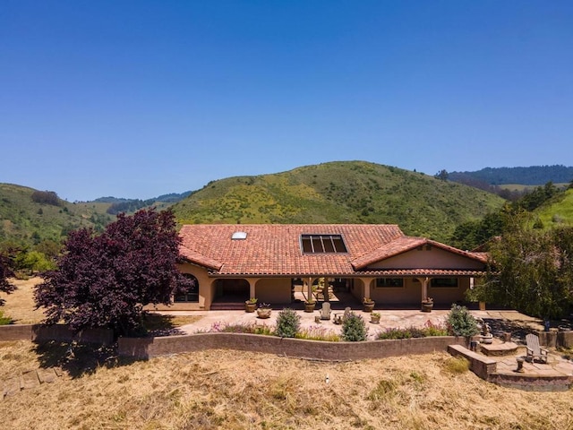 view of front of property with a mountain view and a patio