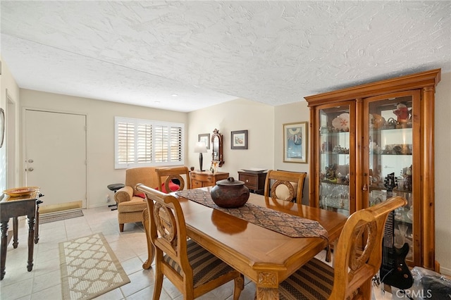 tiled dining room featuring a textured ceiling