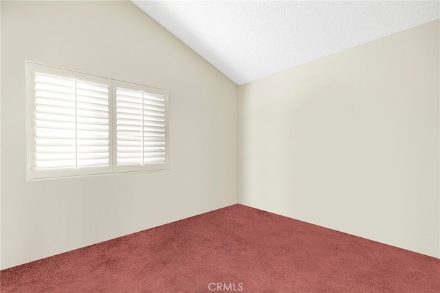 unfurnished room with carpet floors, a textured ceiling, and lofted ceiling