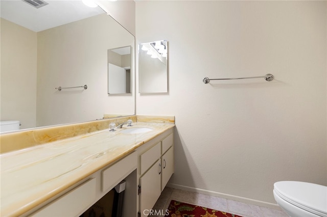 bathroom with tile patterned flooring, vanity, and toilet