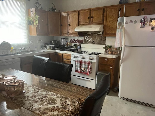 kitchen with tile countertops, sink, and white appliances