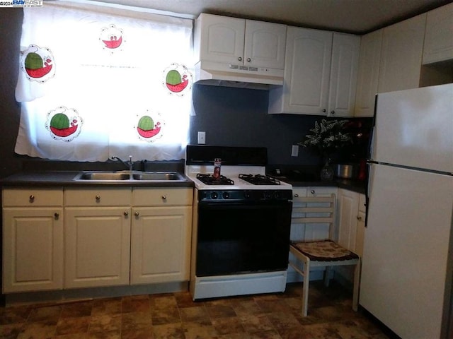 kitchen with white fridge, gas range, white cabinets, and sink