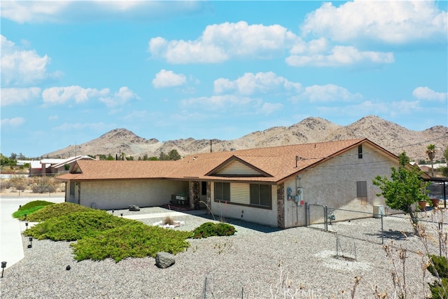 view of front of house featuring stucco siding, fence, a mountain view, and a patio