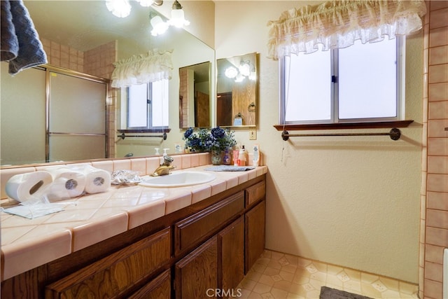 full bathroom with vanity and an enclosed shower