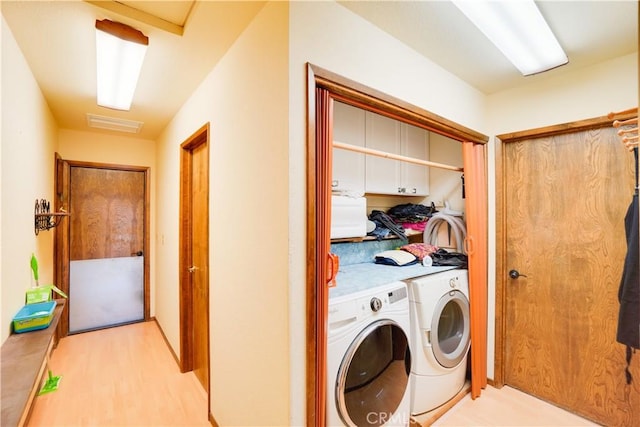 laundry area featuring visible vents, light wood finished floors, and independent washer and dryer