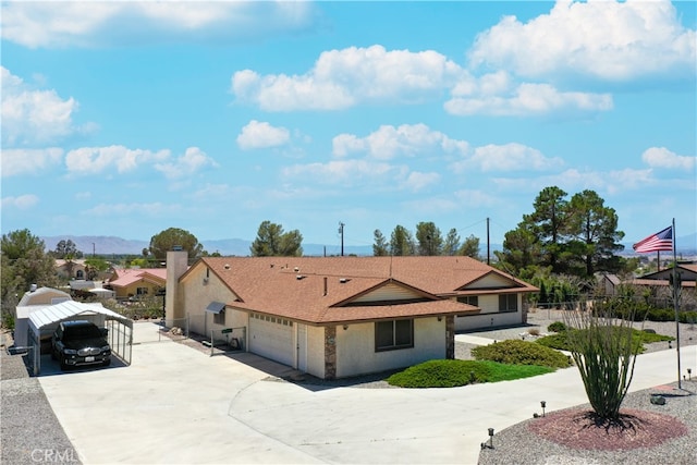 ranch-style home with driveway, fence, an attached garage, and a mountain view