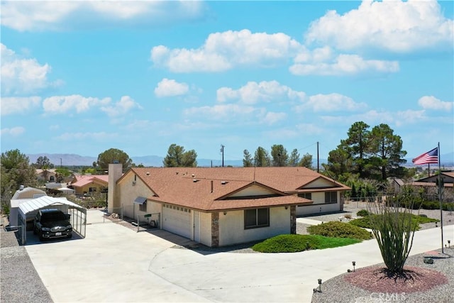 ranch-style home featuring concrete driveway, fence, a shingled roof, and a garage