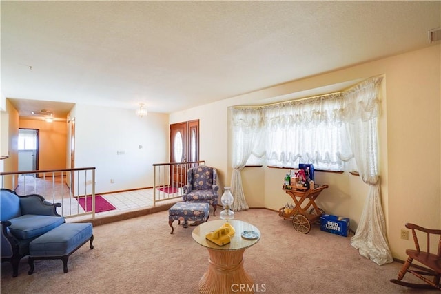 living area featuring visible vents and carpet