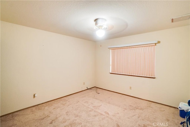 empty room with baseboards, visible vents, and light colored carpet