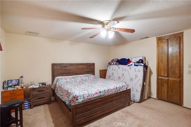 bedroom with light carpet, a ceiling fan, and visible vents