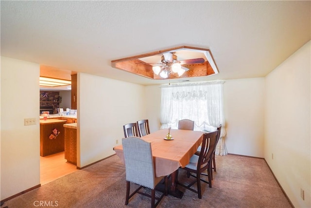 dining area featuring baseboards, ceiling fan, and light carpet