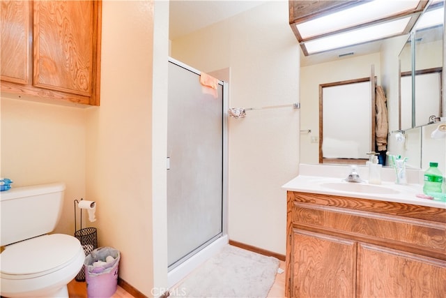 bathroom with toilet, a stall shower, a skylight, and vanity