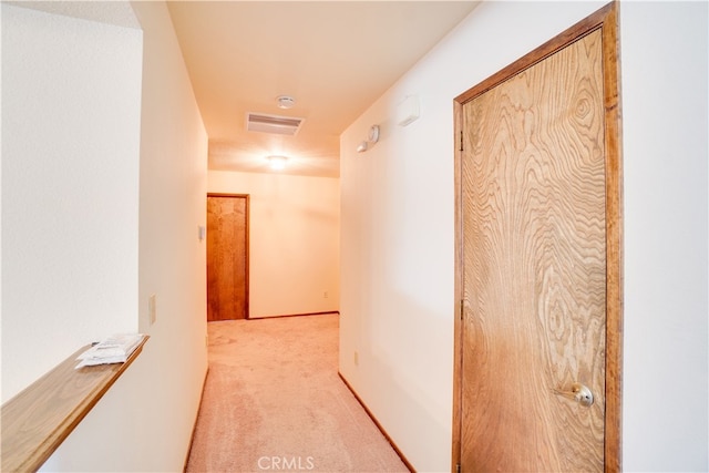 hall featuring light carpet and visible vents