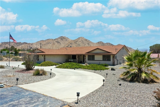 ranch-style home with concrete driveway and a mountain view