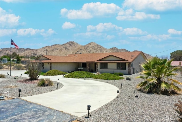 single story home featuring curved driveway and a mountain view