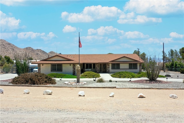 ranch-style house with fence and a mountain view