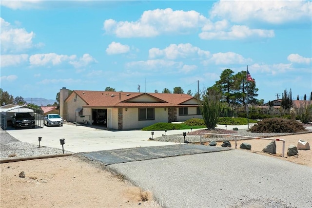 ranch-style home featuring a garage, a carport, and driveway