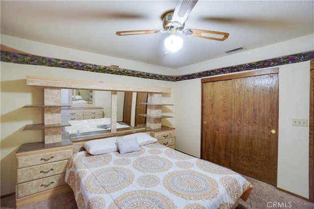 carpeted bedroom with a ceiling fan, a closet, and visible vents