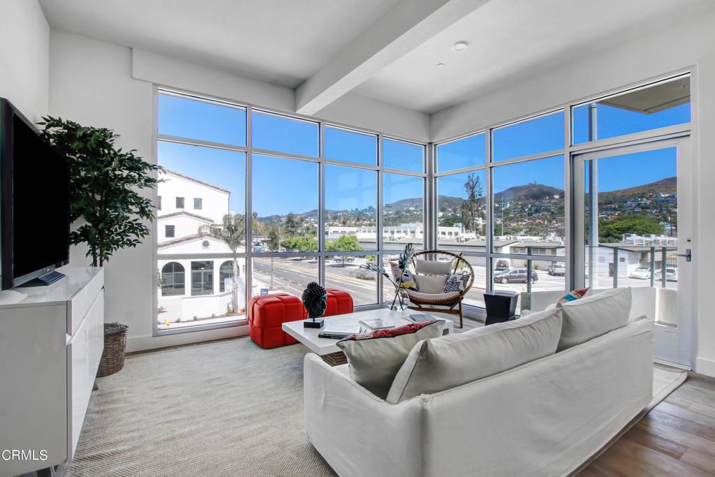 living room featuring a mountain view, beamed ceiling, and wood-type flooring