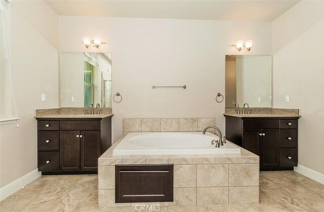 bathroom featuring vanity and a relaxing tiled tub