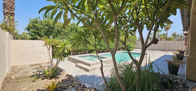 view of pool featuring an in ground hot tub and a patio