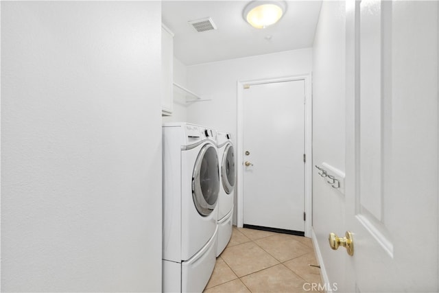 laundry room with light tile patterned floors and washer and clothes dryer