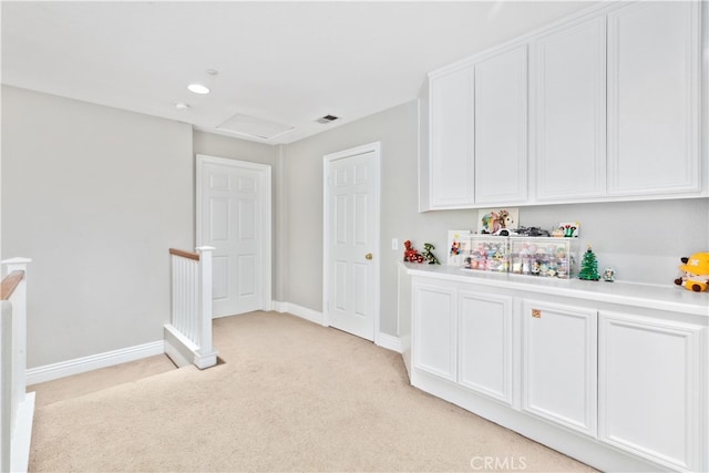 interior space with white cabinetry and light colored carpet