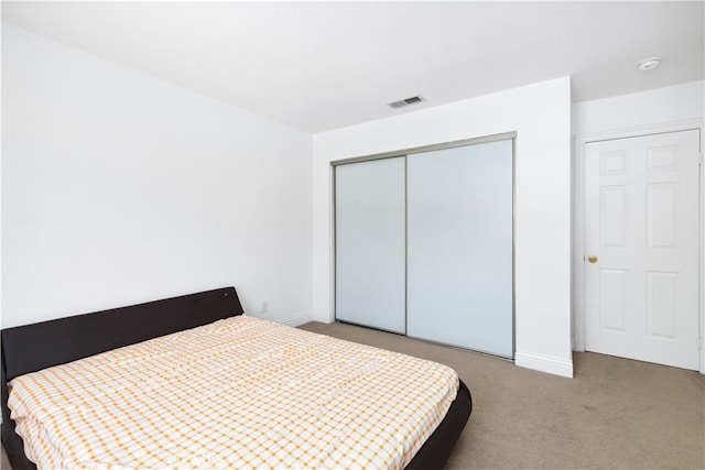 bedroom with carpet and a closet