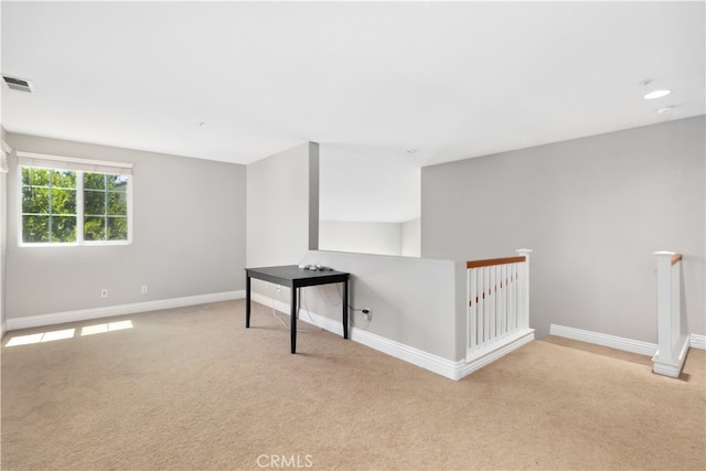 unfurnished room featuring light carpet