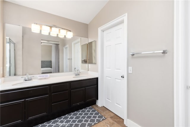 bathroom with vanity, vaulted ceiling, and tile patterned floors