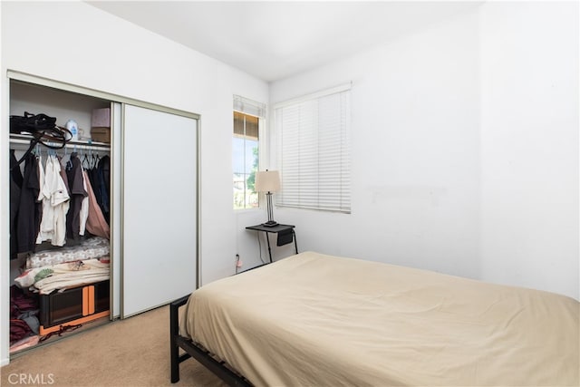 bedroom featuring light colored carpet and a closet