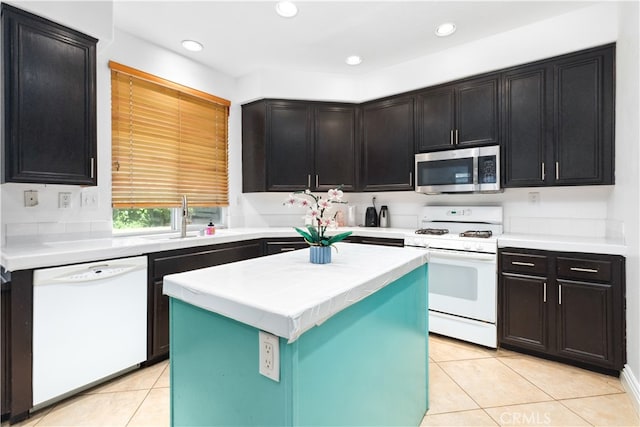 kitchen with white appliances, a kitchen island, sink, and light tile patterned floors