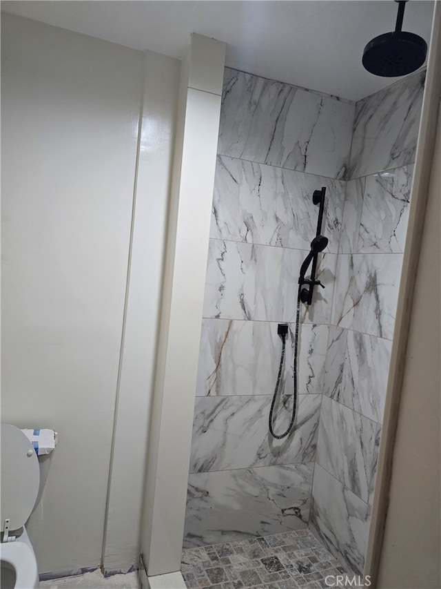 bathroom with tiled shower and toilet