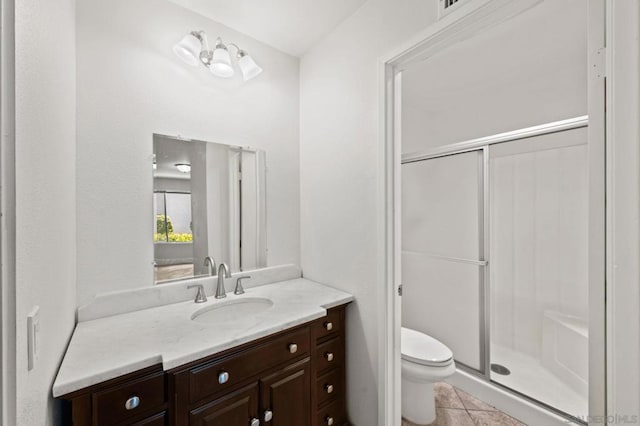 bathroom featuring tile patterned floors, an enclosed shower, vanity, and toilet