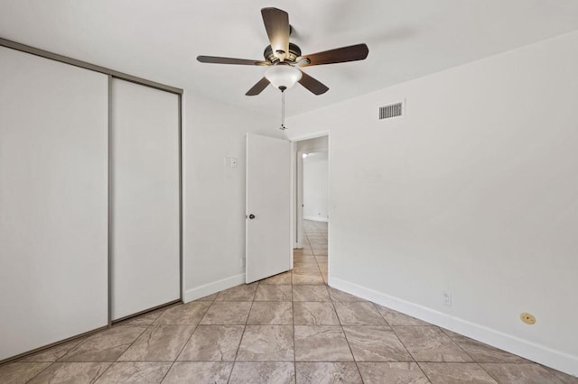 unfurnished bedroom with ceiling fan and a closet