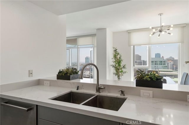 kitchen with a city view, a notable chandelier, a sink, and a healthy amount of sunlight