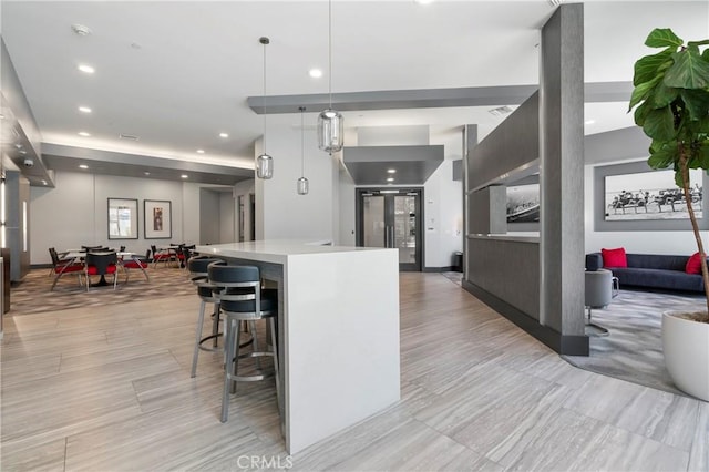 kitchen with open floor plan, light countertops, a kitchen breakfast bar, recessed lighting, and a center island
